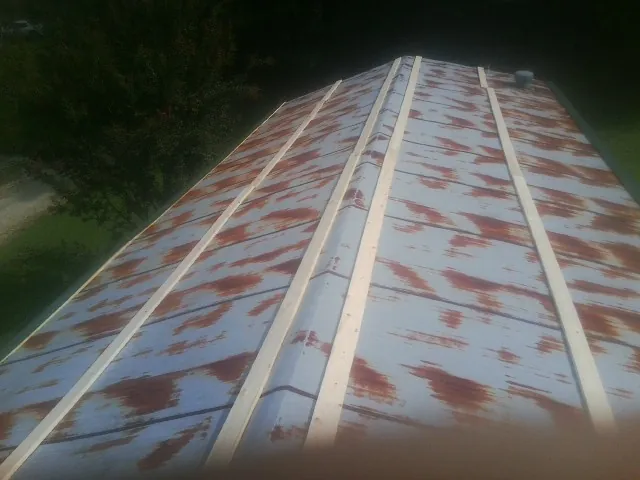 Rusted metal roof panels with new wood purlins before replacement — Storm Damage Roof Repair in Dahinda by Roofing Brothers
