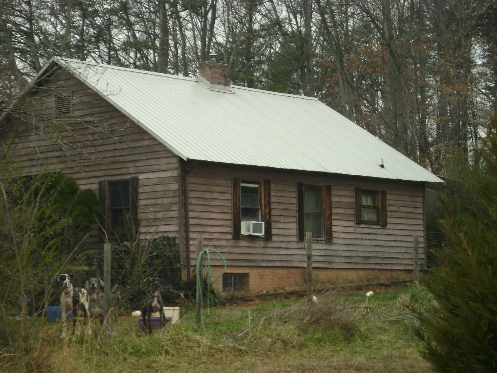 White metal roof on an old wood sided farmhouse, from a Metal Roof Installation job in Dahinda